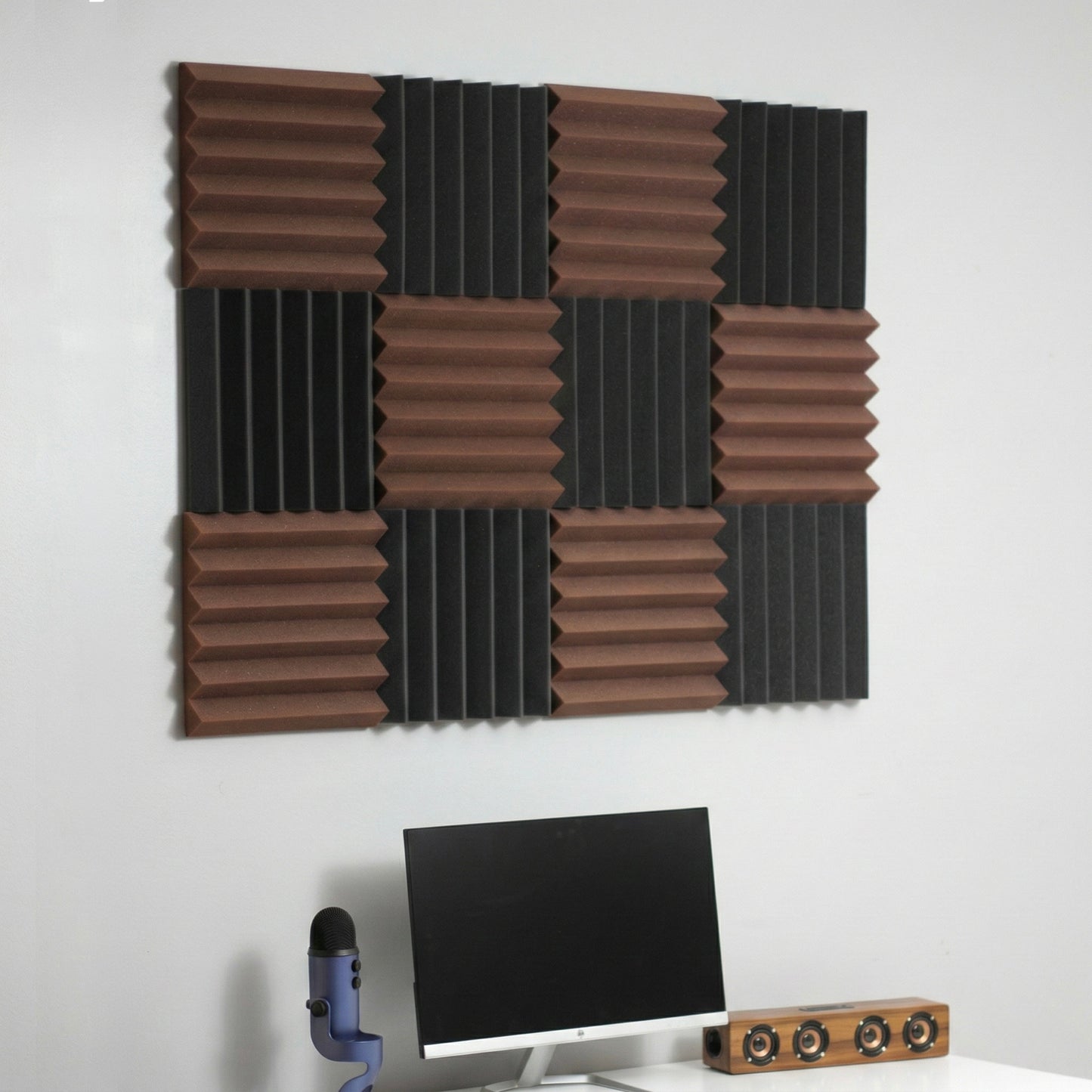 Acoustic foam panels on a wall above a computer setup